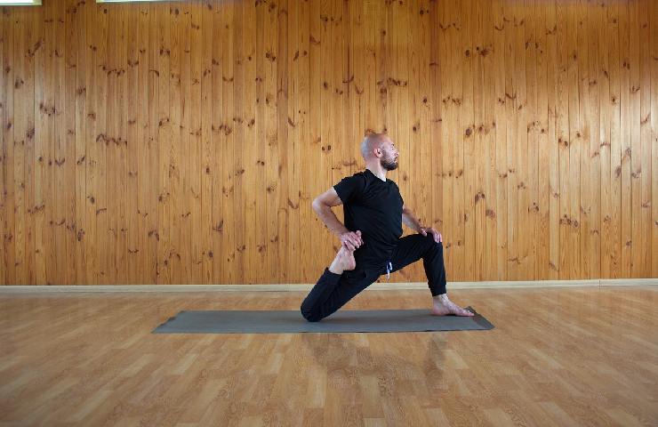 Uomo che fa stretching su un tappetino