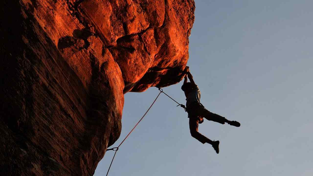 Una persona intenta ad arrampicarsi