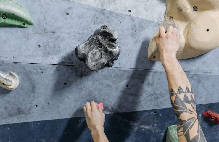 Climber che scala una parete di arrampicata sportiva