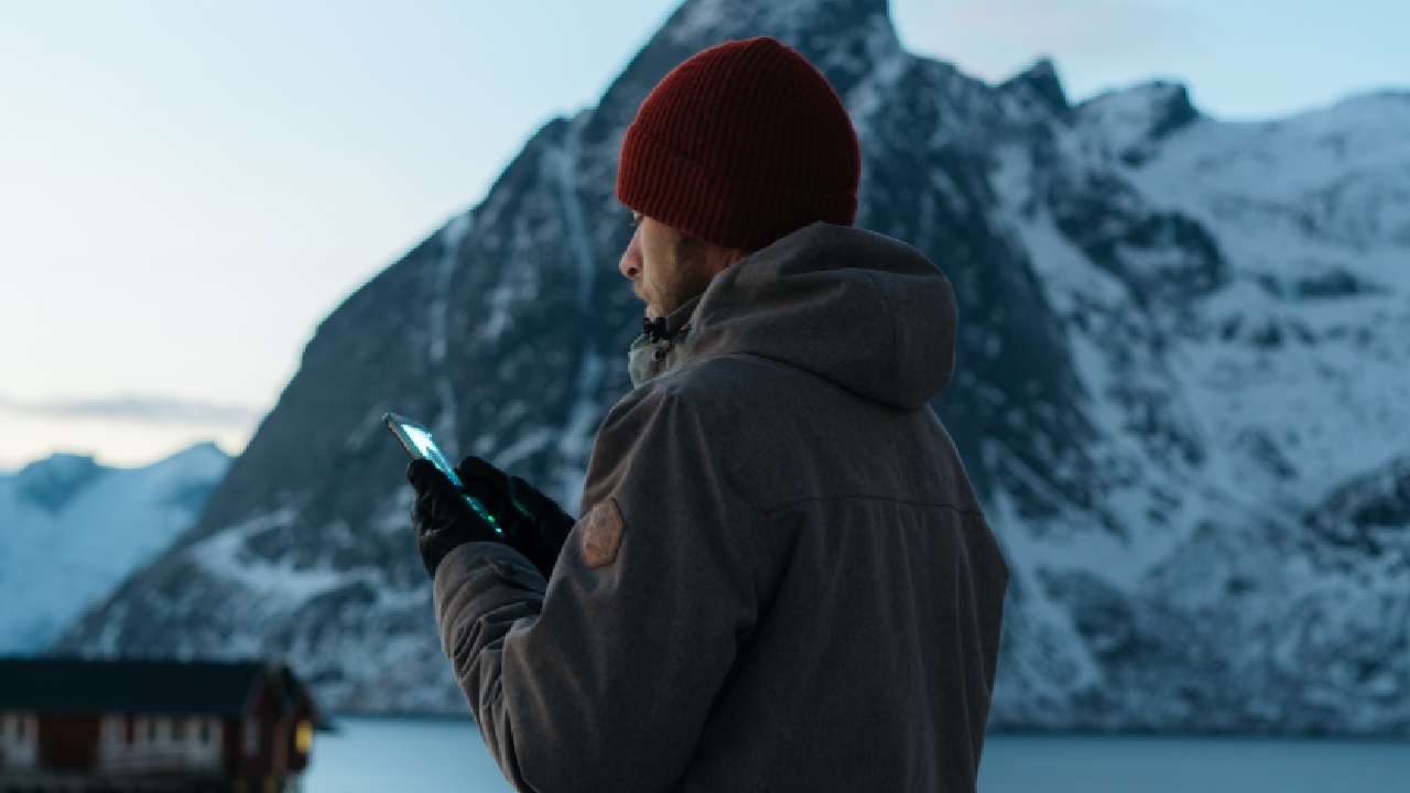 Uomo che cerca il segnale in montagna