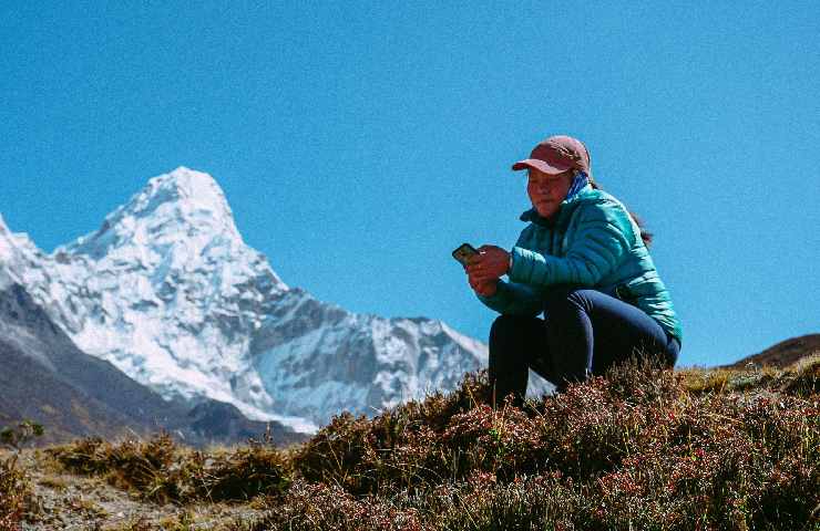 Donna che parla al telefono in montagna