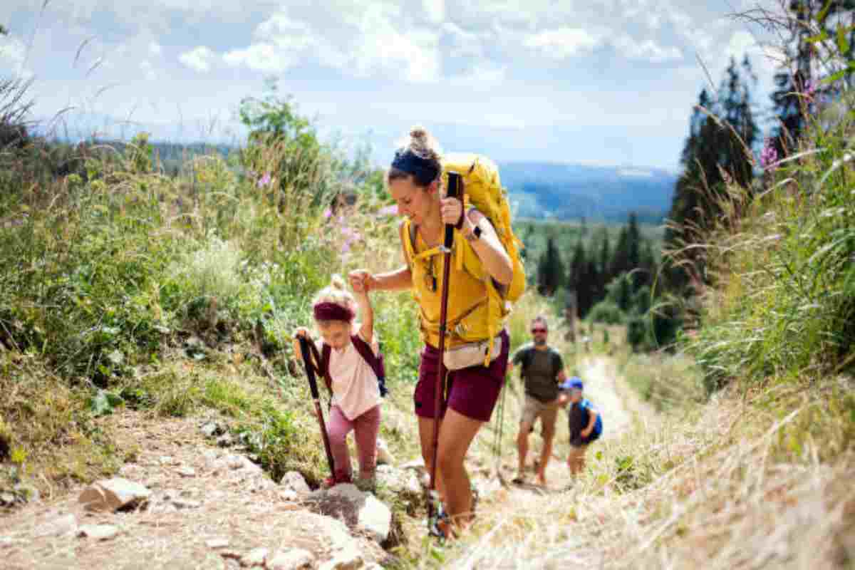 Famiglia con bambini fa trekking in montagna