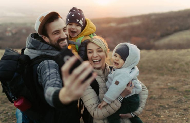 Genitori con figli piccoli fanno un selfie in montagna