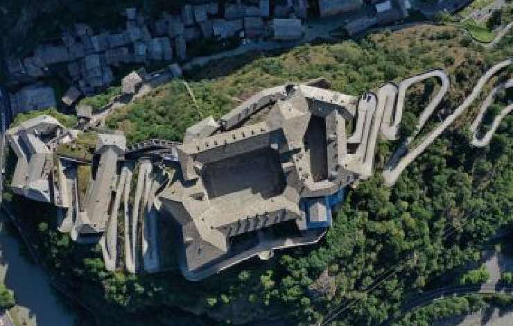 Vista dall'alto di un antico forte fatto di pietra, strade serpentine e tetti squadrati, in cima ad una altura