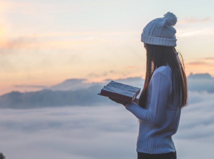 ragazza che legge un libro in montagna