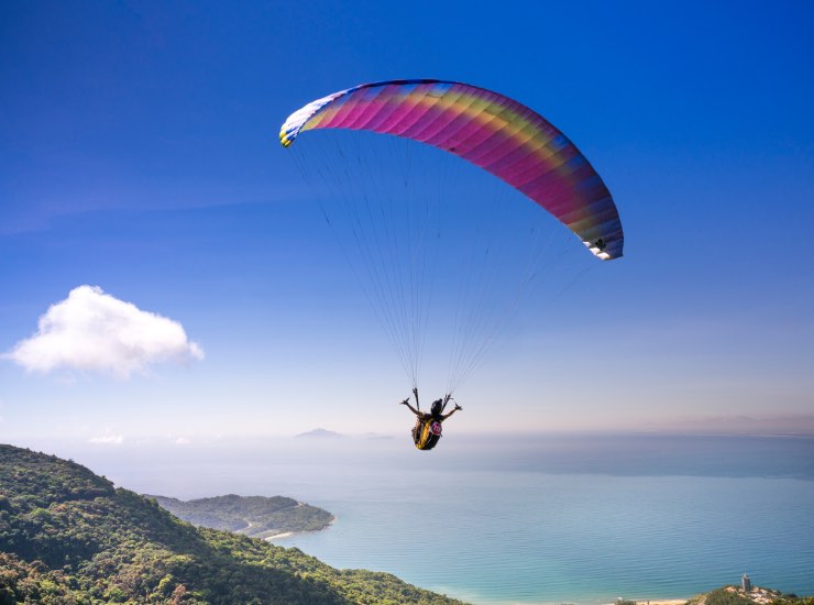 Parapendio colorato con sfondo di lago e montagne