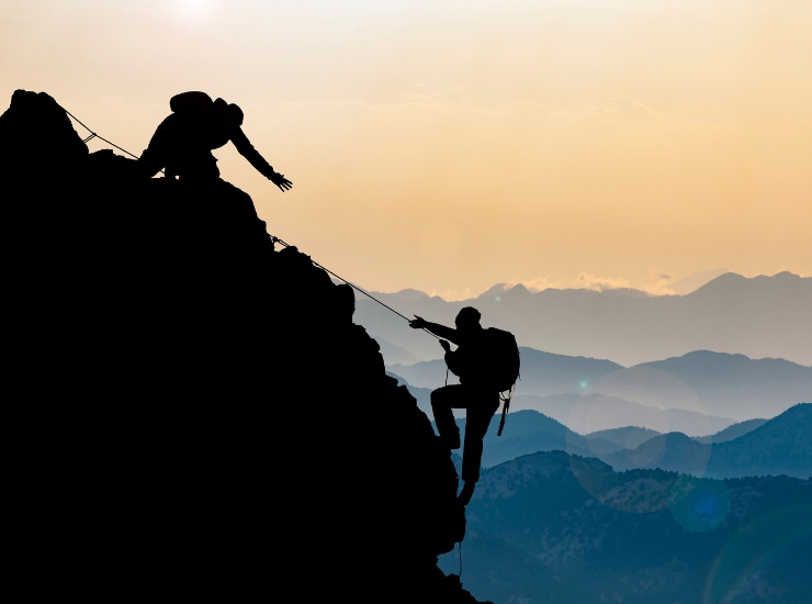 due uomini in cordata scalano una montagna