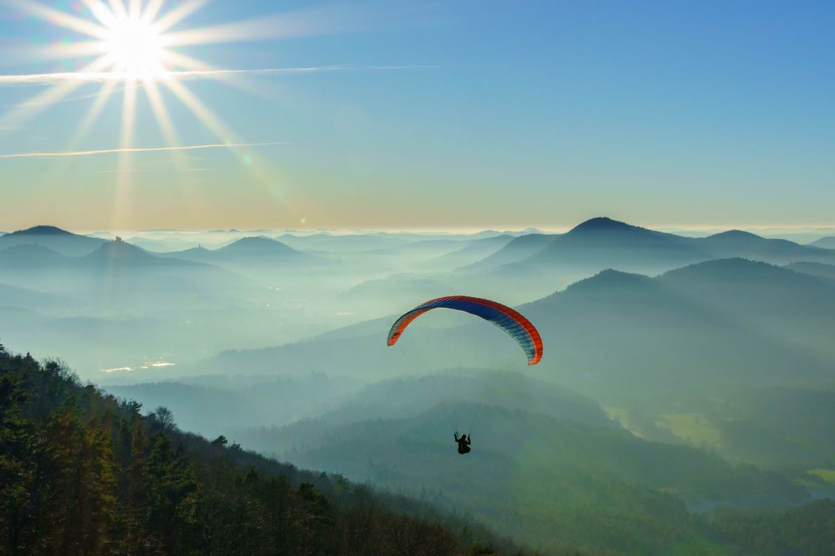 Parapendio sulle montagne con il sole