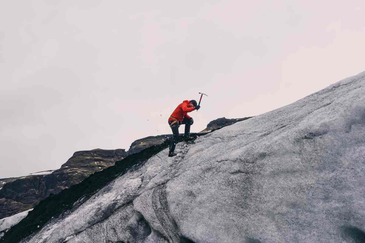 Uomo usa una piccozza in montagna