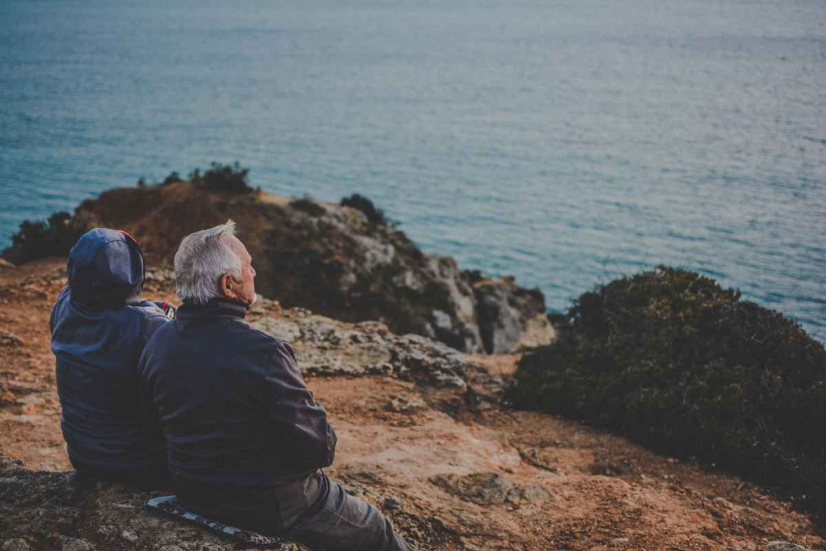 Coppia anziani osserva il mare da una rupe