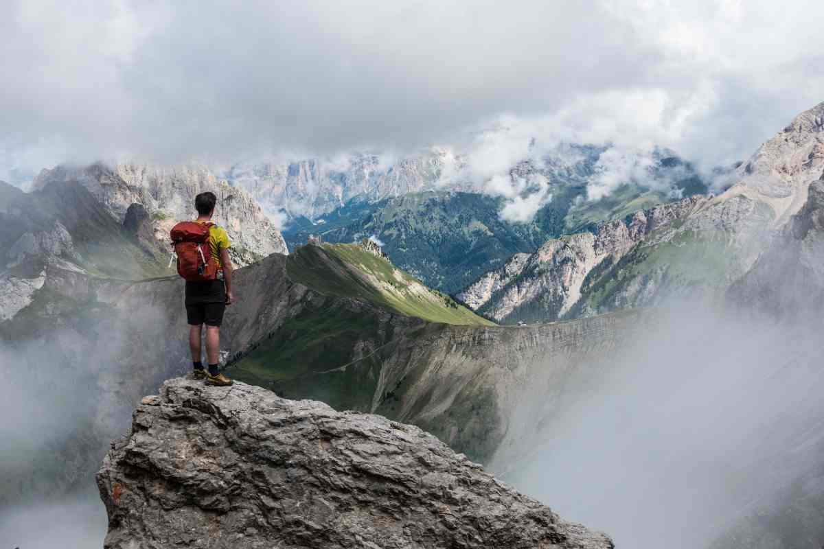 Ragazzo in cima a un monte osserva la vallata