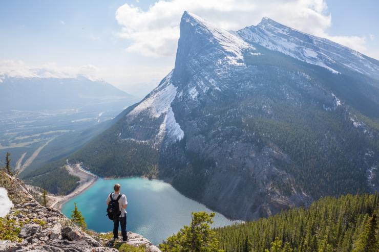 Uomo osserva il lago dalla montagna