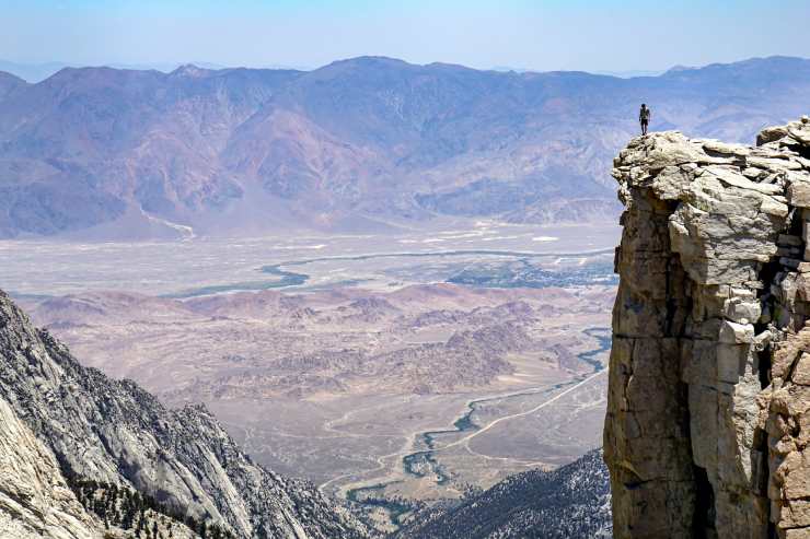Uomo sul precipizio di una montagna prova un senso di vertigini