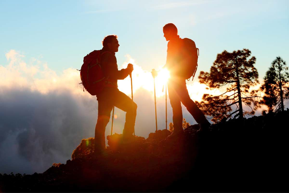 Due persone in scalata parlando davanti all'alba