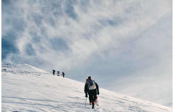 un gruppo di alpinisti sul crinale innevato