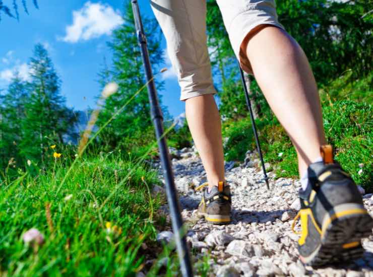 Ragazza che sale la montagna in tenuta da trekking