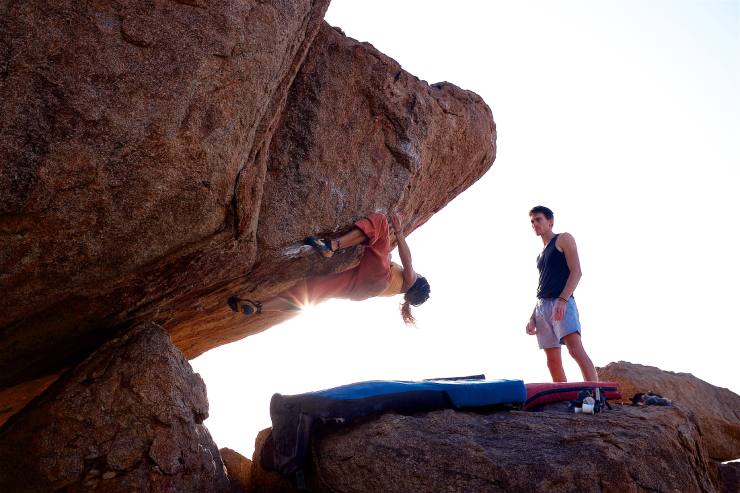 Atleti scalano una roccia in montagna