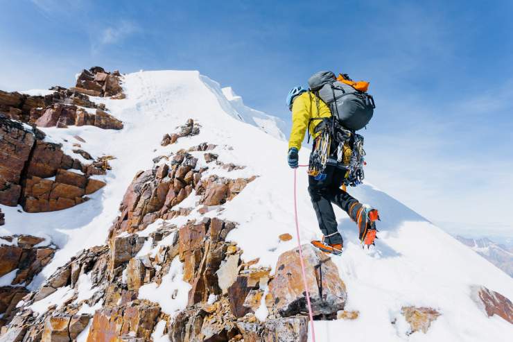 Uomo compie alpinismo in montagna