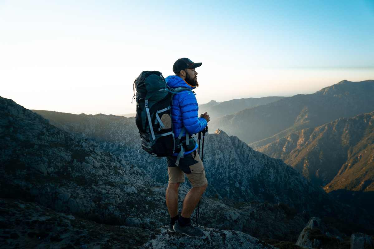 Uomo con zaino da trekking in spalla in montagna