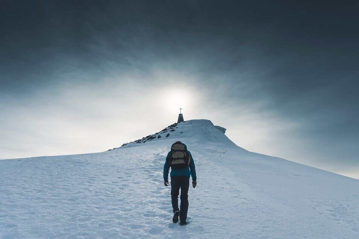 uomo fa trekking in montagna sulla neve