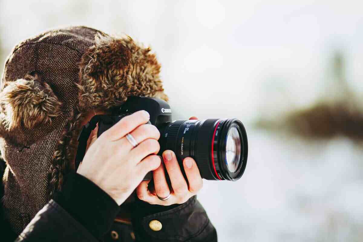 uomo che fotografa con macchina fotografica in montagna