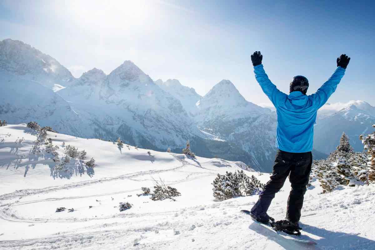 Un uomo esulta guardando le montagna