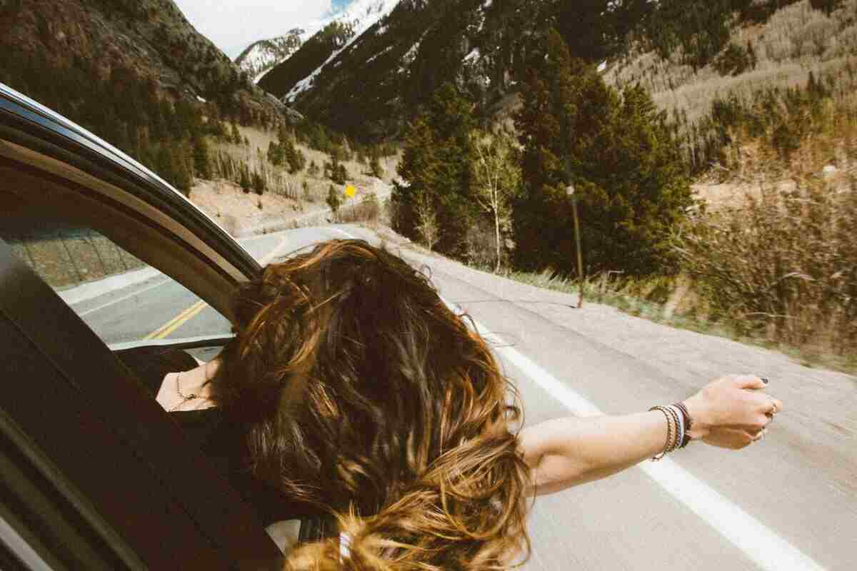 ragazza in auto verso località di montagna