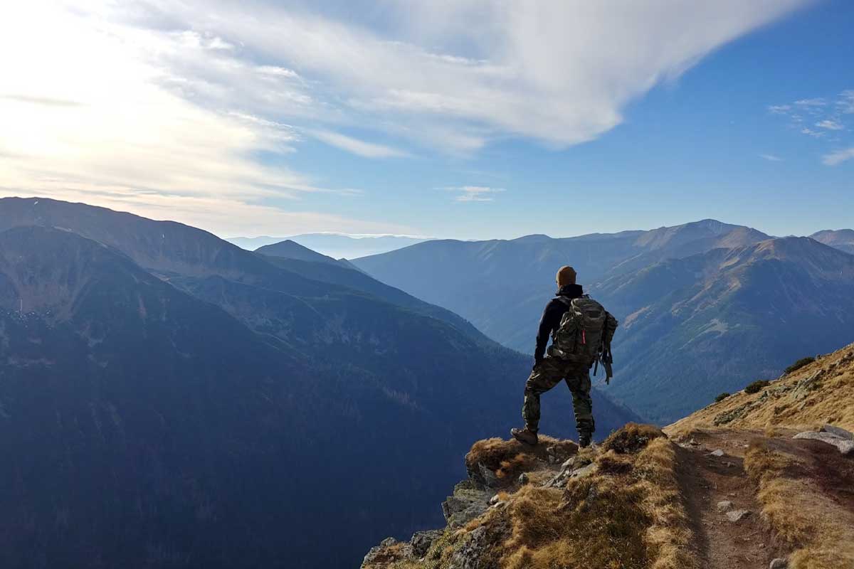 Uomo sul pendio di una montagna pronto all'avventura